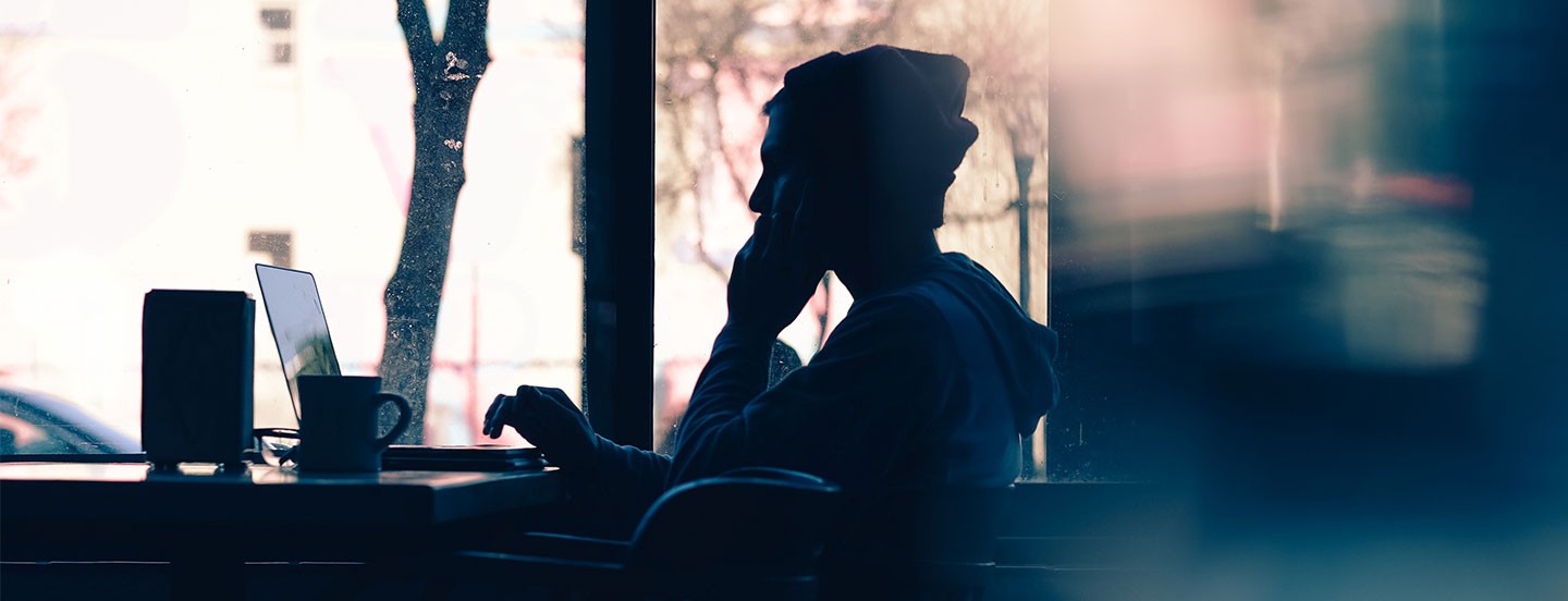 man working in cafe at a laptop