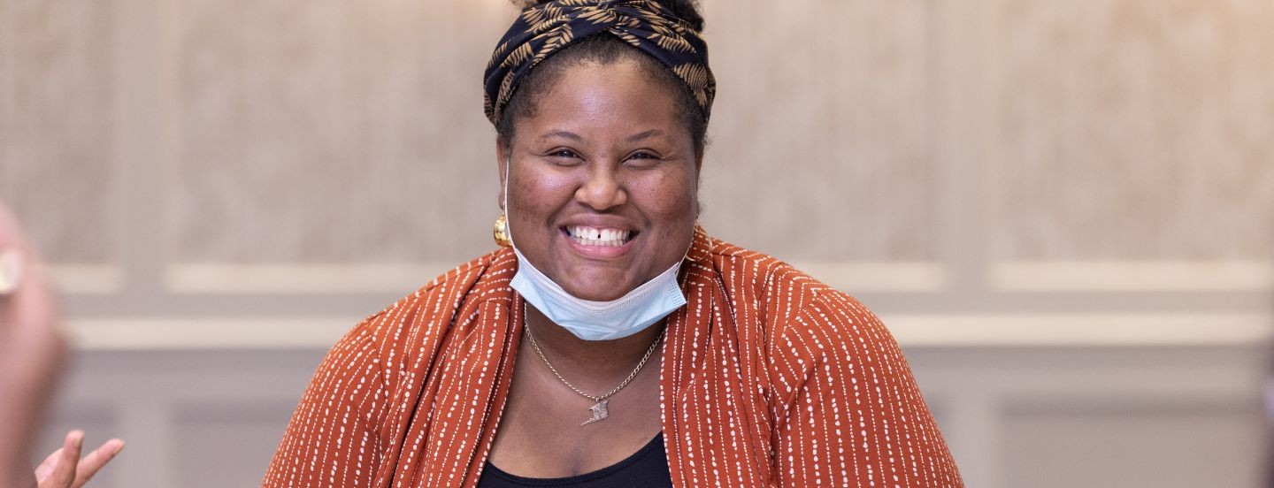 woman with mask lowered smiling at camera