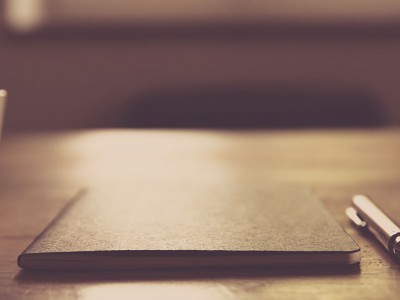 cup of coffee, notebook, pencil and cellphone on table