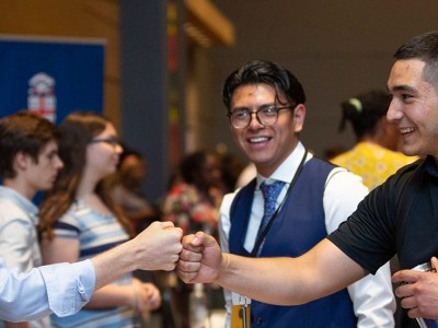 Mentor and mentees fist bump and smile